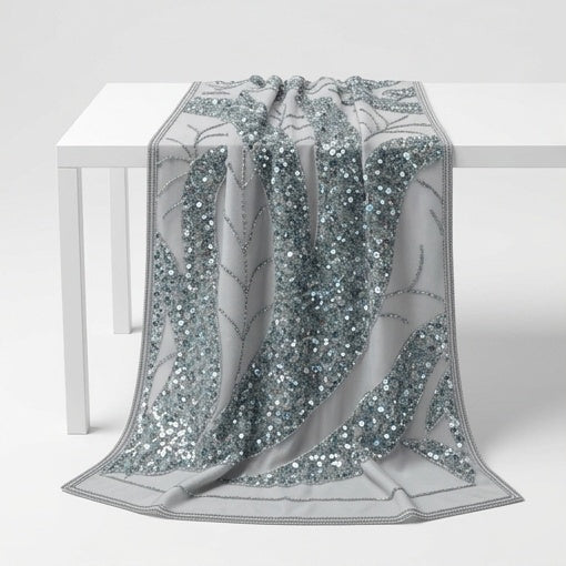 Tissu Gris perle brodé drapé sur une table