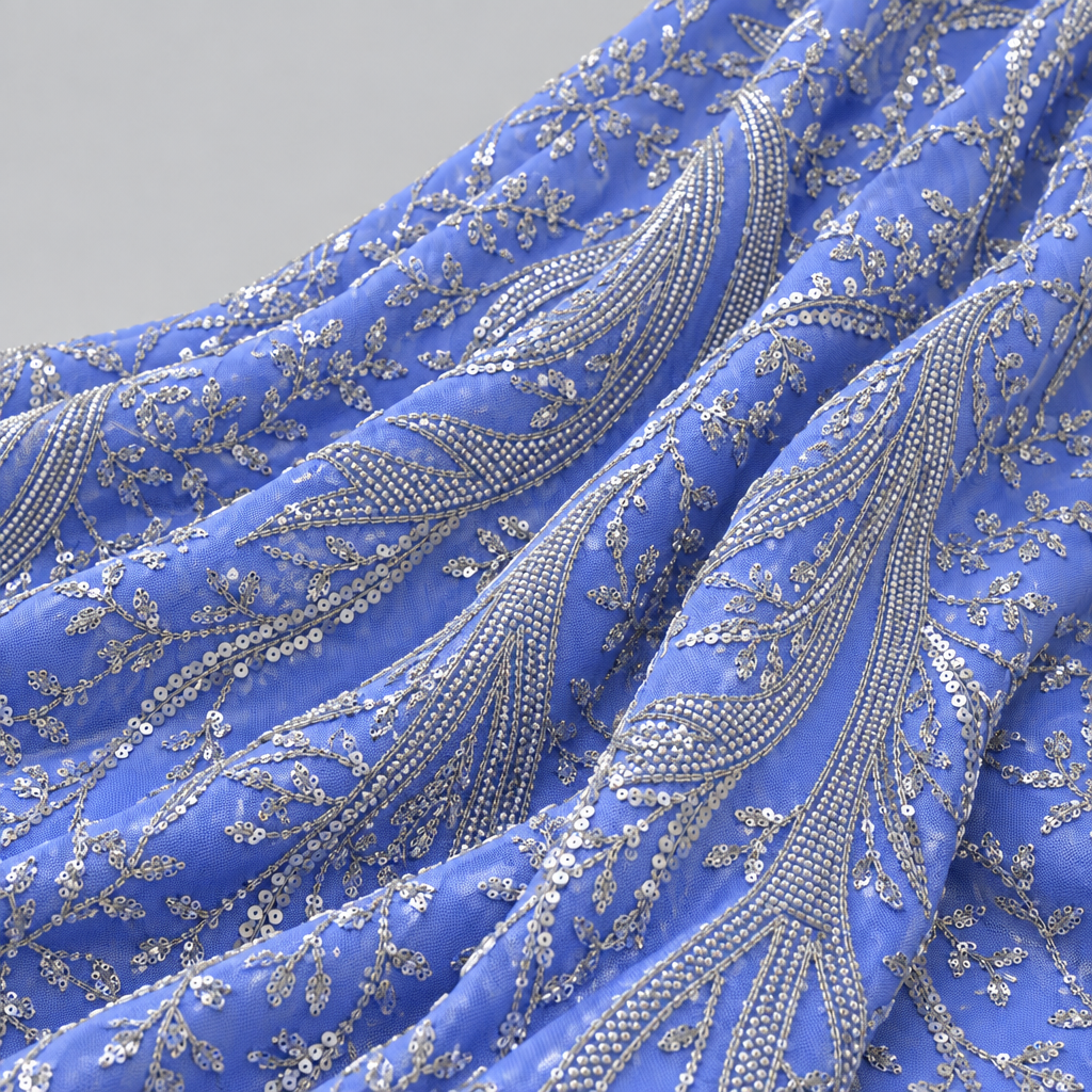 Periwinkle blue embroidered fabric draped in soft folds, light grey background